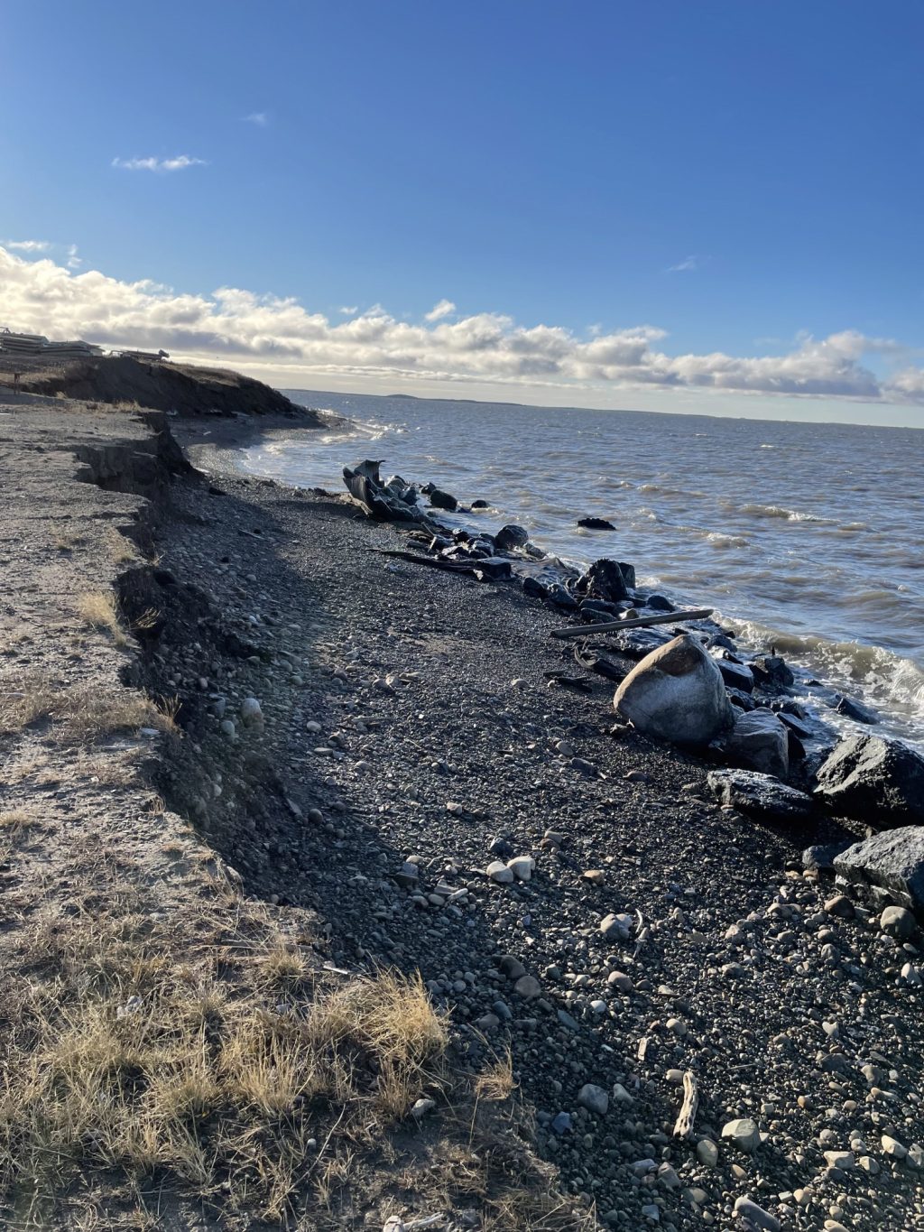 A rocky beach with a body of water in the background