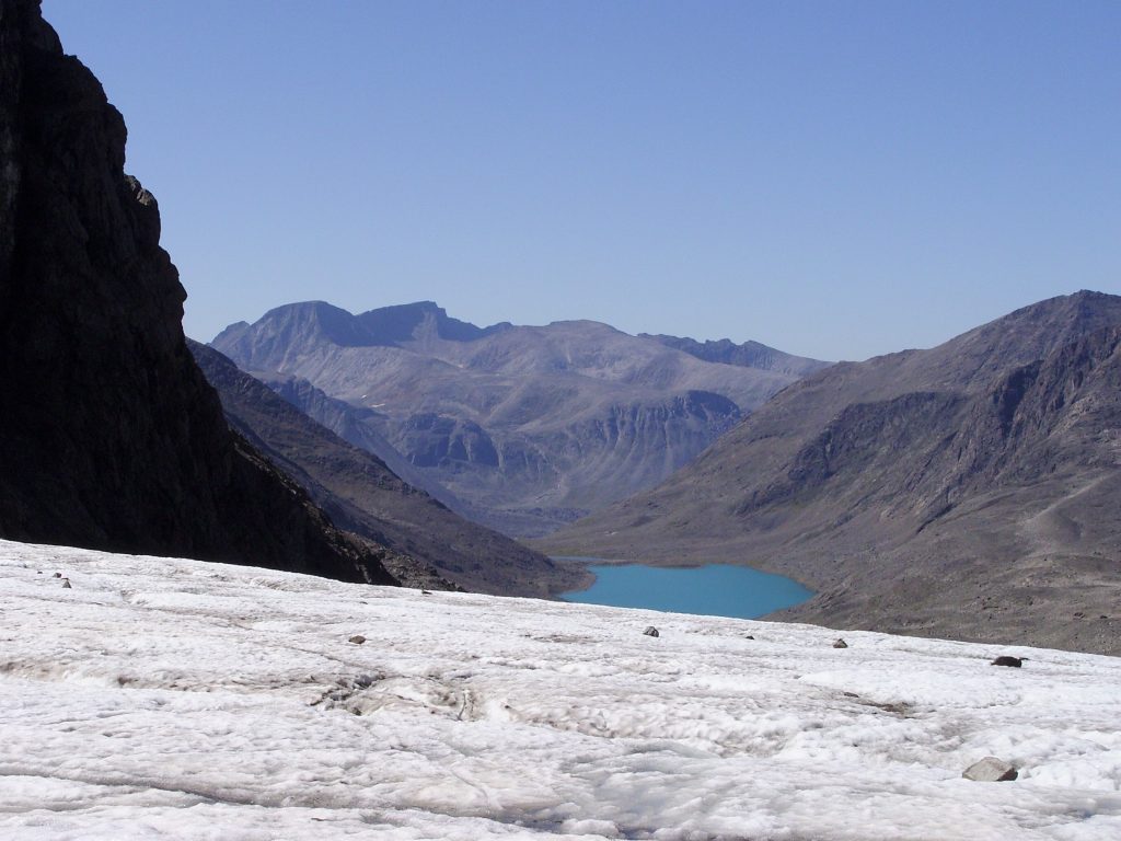 A picture containing mountains, nature, ice and a lake.